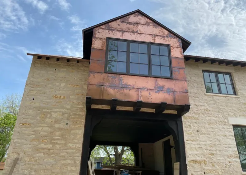 Copper metal panel facade on a stone building for Skylight Installation in Mustang